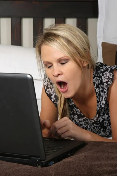 Mujer bostezante y computadora portátil —  Fotos de Stock