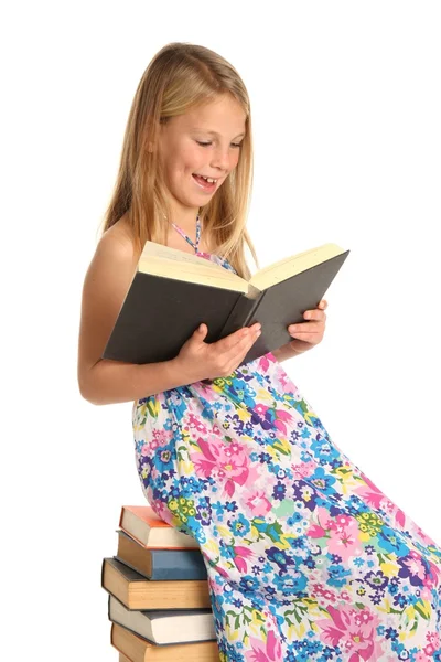Roztomilý školačku, sedící na knihách — Stock fotografie