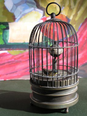 A bird in a metal birdcage . clipart