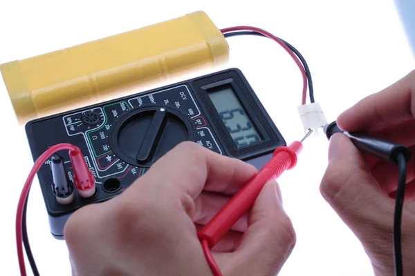 Χρησιμοποιήστε το πολύμετρο να meterage μια μπαταρία. — Φωτογραφία Αρχείου