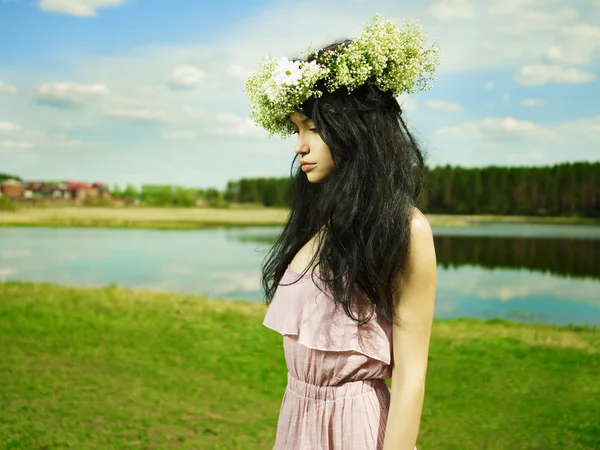 Hermosa chica con una corona de flores silvestres — Foto de Stock
