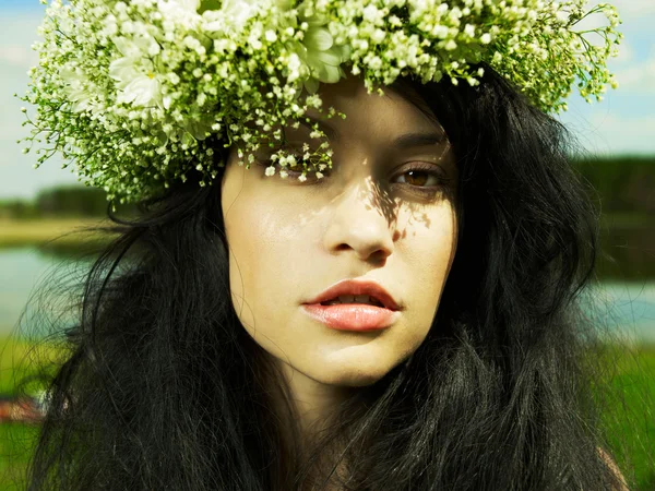 Menina bonita vestindo uma coroa de flores silvestres — Fotografia de Stock