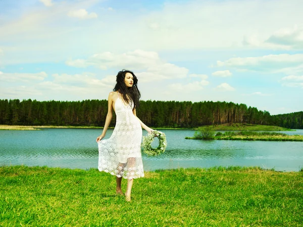 Красивая девушка в венке из полевых цветов — стоковое фото