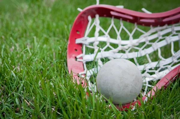 Meninas cabeça de lacrosse e bola cinza na grama — Fotografia de Stock