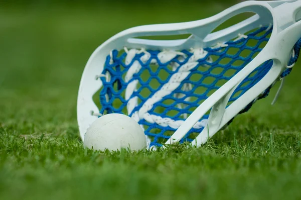 Lacrosse stick met bal op gras — Stockfoto
