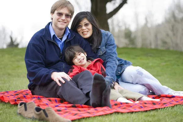 Bello padre seduto al parco con figlio disabile — Foto Stock