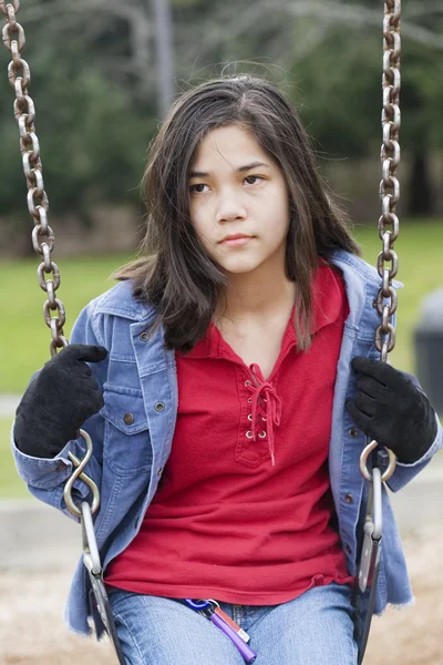 Irritado, triste menina pré-adolescente sentado no balanço — Fotografia de Stock