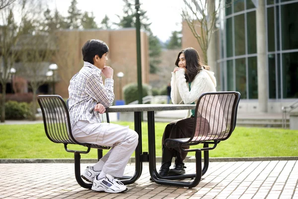 Two young teenagers sitting talking together outdoors — Stock Photo, Image