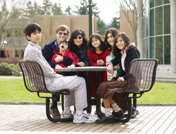 Vacker interracial familj sitter tillsammans utomhus — Stockfoto