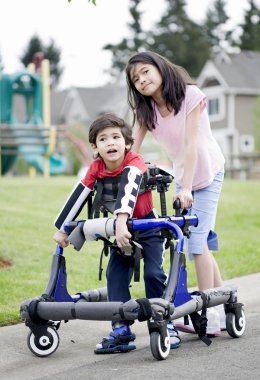 Big sister helping younger disabled brother in walker clipart