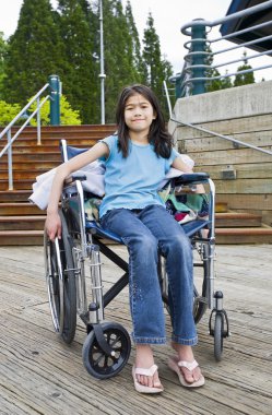 Young girl in wheelchair in front of stairs clipart