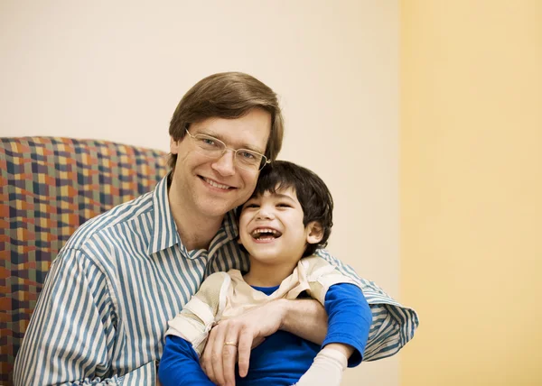 Отец держит сына-инвалида в кабинете врача — стоковое фото
