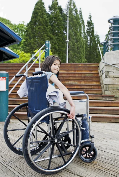 Giovane ragazza in sedia a rotelle di fronte alle scale — Foto Stock