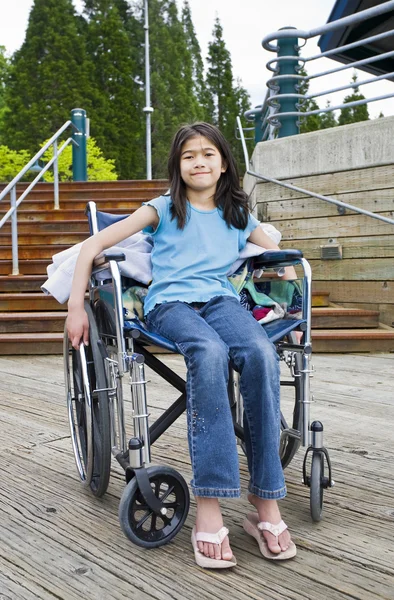 Молодая девушка в инвалидной коляске перед лестницей — стоковое фото