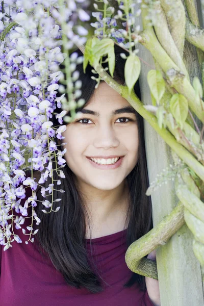 Mooie tiener meisje permanent blauweregen wijnstokken beplante — Stockfoto
