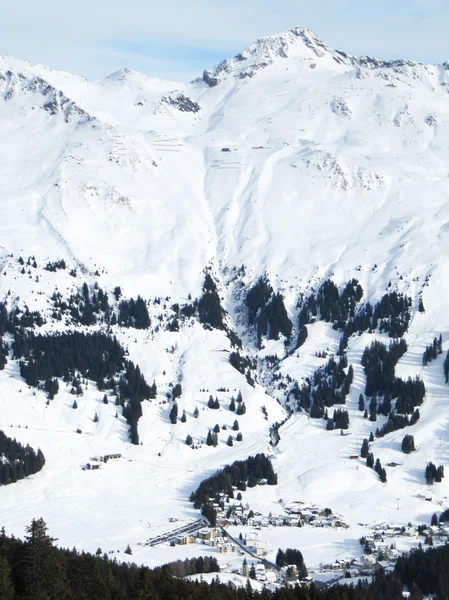 Encostas de esqui íngremes com aldeia — Fotografia de Stock