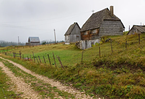 Будинки з дерев'яної дранки по грунтовій дорозі, типовий сільських vi Montenegran — стокове фото