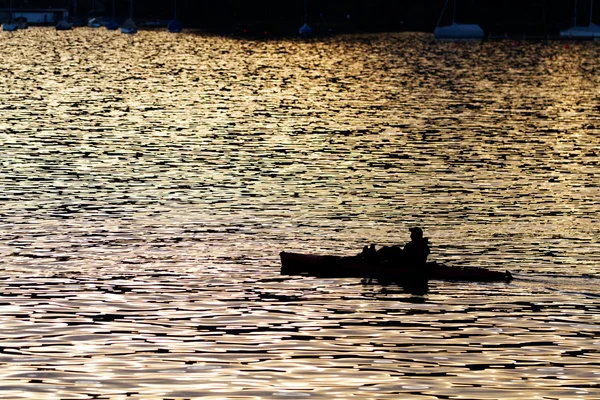 Magányos ember a kajak, sziluett naplementekor — Stock Fotó