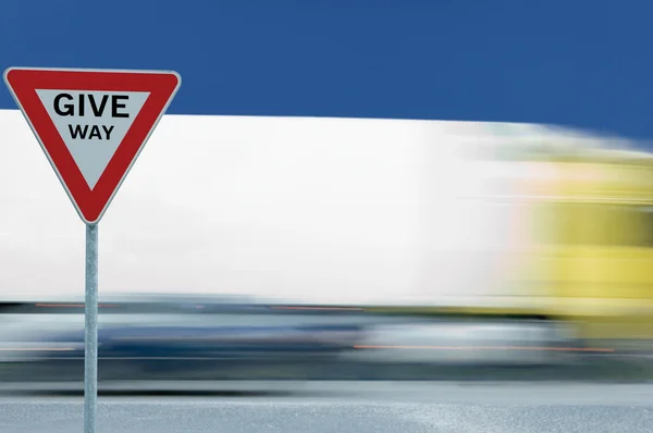 Give way yield traffic sign and moving truck — Stock Photo, Image