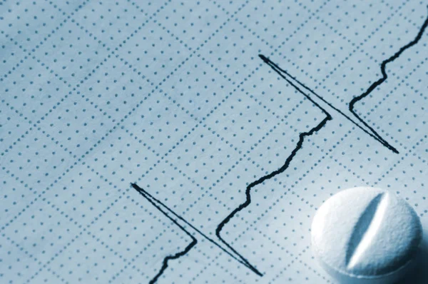 Gráfico de fita de cardiograma Macro Closeup e pílula em azul — Fotografia de Stock