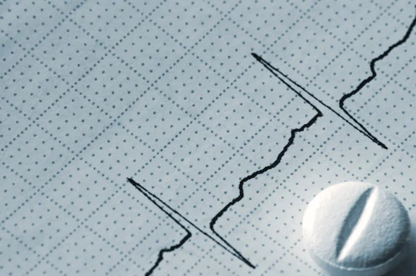 Gráfico de cinta cardiográfica Macro primer plano y píldora en azul — Foto de Stock