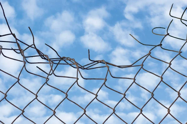 Granica wieku zgnieciony, zardzewiały drutami bezpieczeństwa nad cloudscape — Zdjęcie stockowe