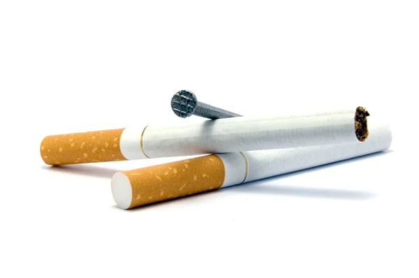 Cigarety a hřebík rakev metafora, izolované makro detail — Stock fotografie