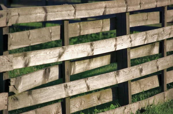 Горизонтальная деревянная ограда в траве — стоковое фото