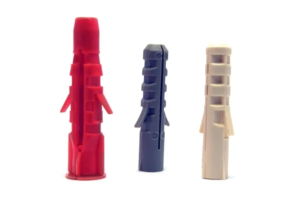 Plastové kolíky zástrčky, červená, slonová kost, šedá, izolované makro detail — Stock fotografie