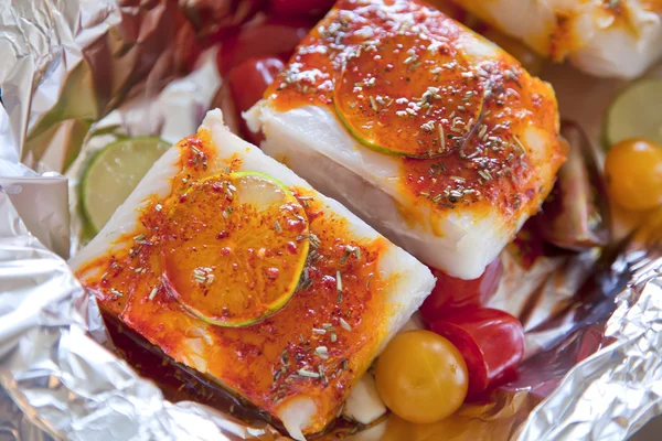 Vit fisk med grönsaker och saffran i folie skifte — Stockfoto