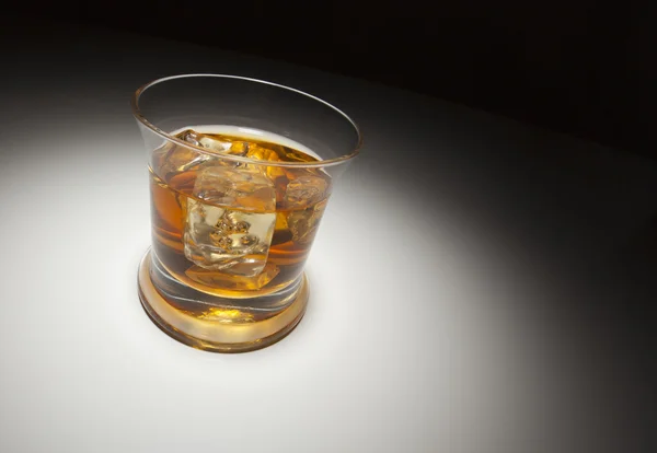 Vaso de whisky y hielo bajo la luz del punto — Foto de Stock