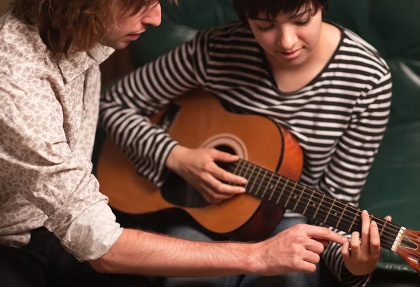 Młody muzyk uczy kobiet student się grać na gitarze — Zdjęcie stockowe