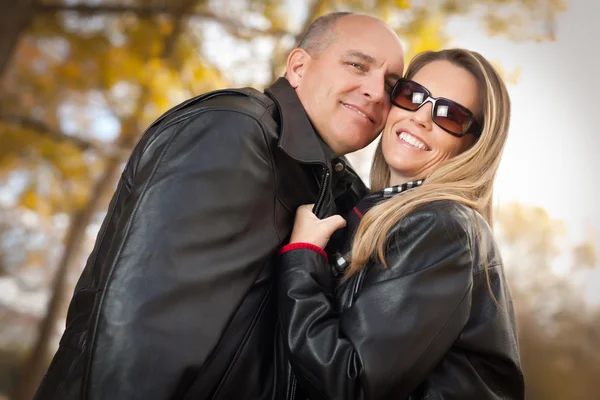 Atractiva pareja en el parque con chaquetas de cuero —  Fotos de Stock
