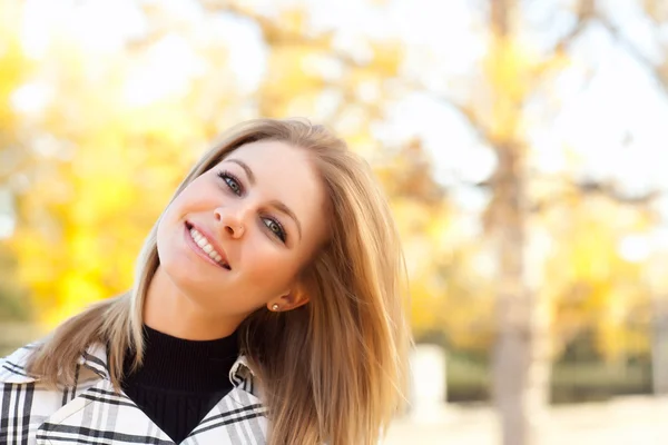 Досить молода жінка посміхається в парку — стокове фото