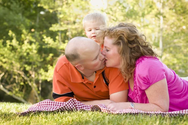 Casal afetuoso beijo como bonito filho olha — Fotografia de Stock