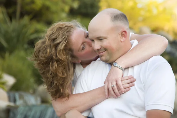 Atractivo beso de pareja en la mejilla en el parque . —  Fotos de Stock
