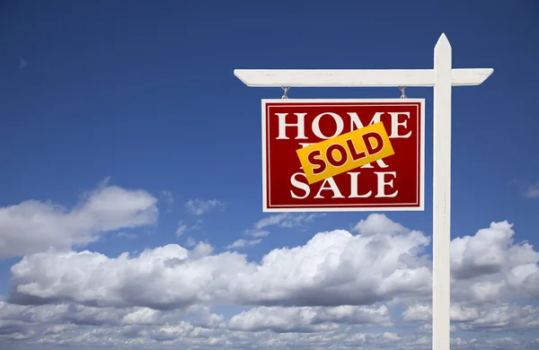 Casa vendida vermelha para venda Sinal imobiliário sobre nuvens e céu — Fotografia de Stock