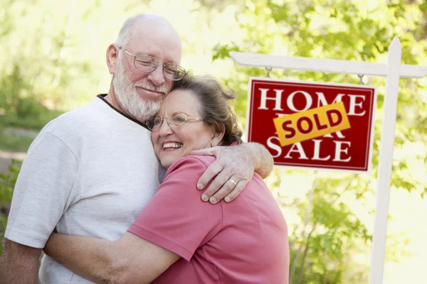 Старша пара перед значком проданої нерухомості — стокове фото
