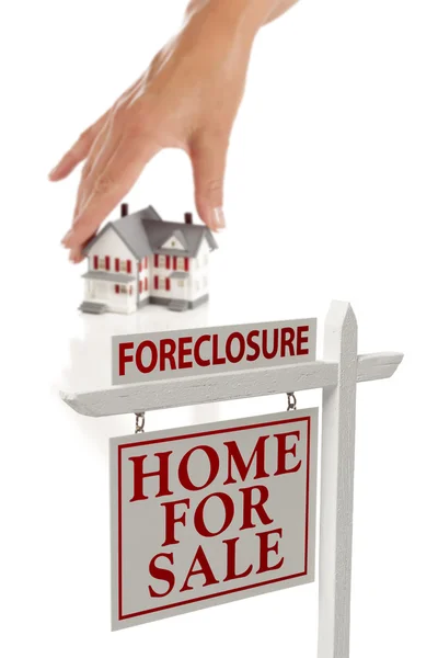 Mão das mulheres escolhendo casa com Foreclosure sinal imobiliário — Fotografia de Stock
