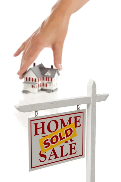 Dames hand kiezen home met verkocht onroerend goed teken — Stockfoto