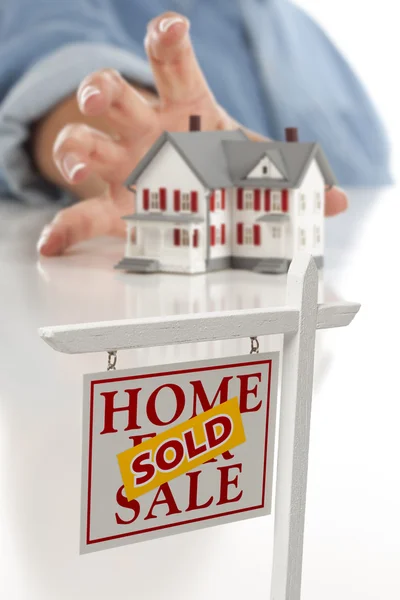 Verkauftes Immobilienschild vorne, Frau greift nach Haus — Stockfoto