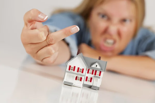 Angry Woman Flipping The Bird Behind Model Home on White — Stock Photo, Image