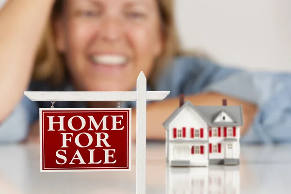 Smiling Woman Behind Real Estate Sign House on a White Surface — Stock Photo, Image