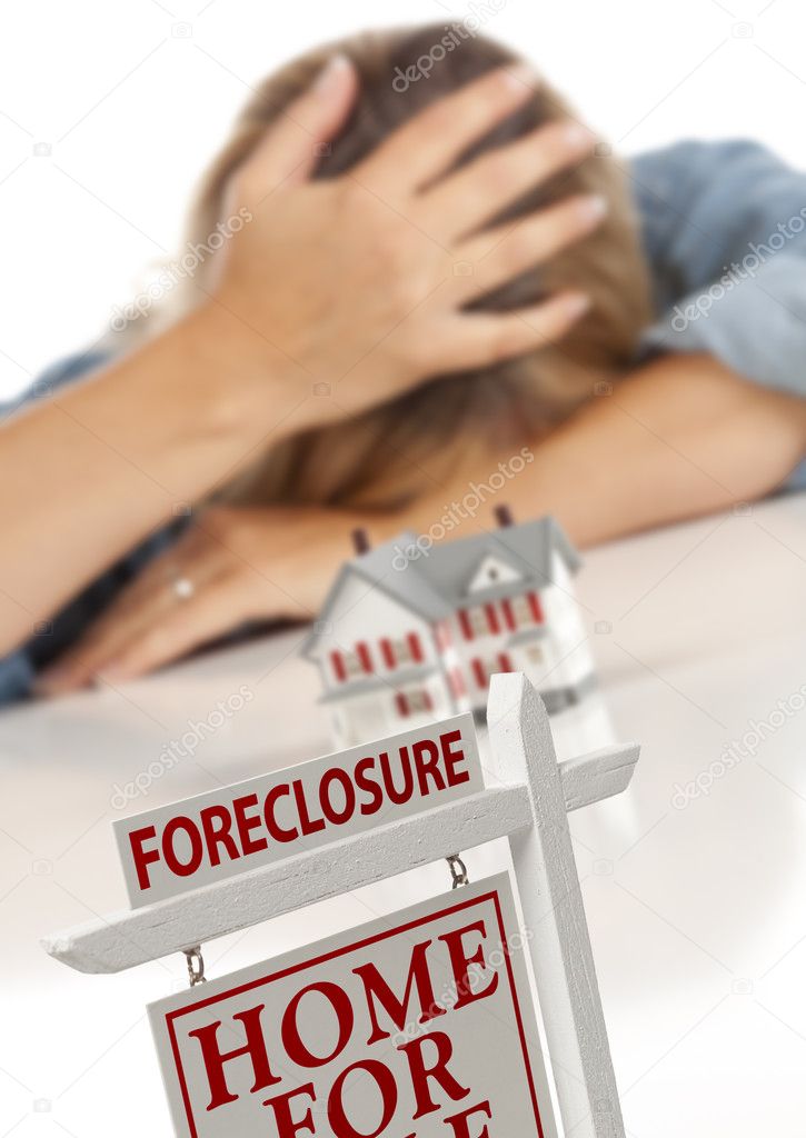 Woman, Head in Hand Behind Model Home and Foreclosure Sign