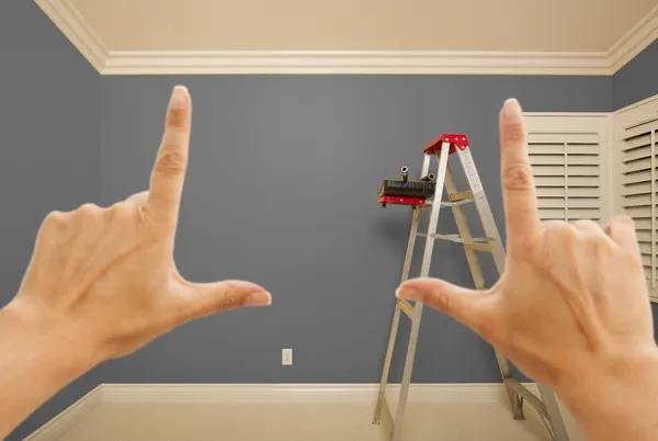 Руки обрамляют интерьер серой окрашенной стены — стоковое фото