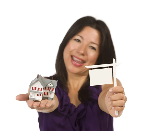 Mujer multiétnica sosteniendo pequeño signo de bienes raíces en blanco y la casa —  Fotos de Stock