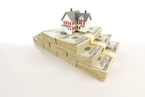 Pequeña casa en pilas de billetes de cien dólares — Foto de Stock