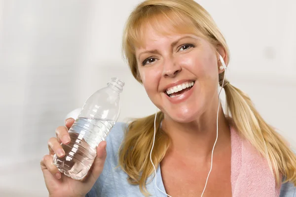Красивая блондинка с полотенцем, пьющим из бутылки с водой — стоковое фото
