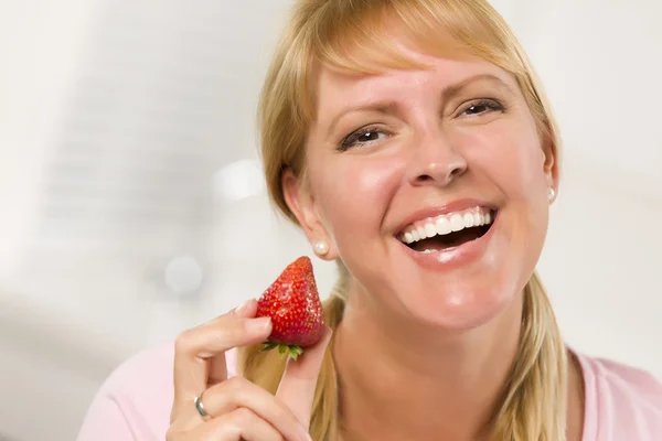 Bastante sorridente loira mulher segurando morango — Fotografia de Stock