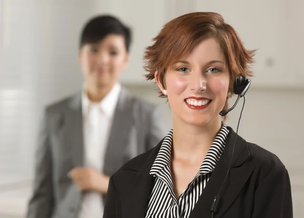 Kırmızı saçlı iş kadını ofiste kulaklık ile — Stok fotoğraf